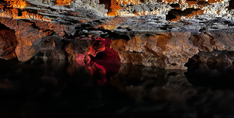 بازتاب قندیل‌های آهکی و نورپردازی قرمز و نارنجی