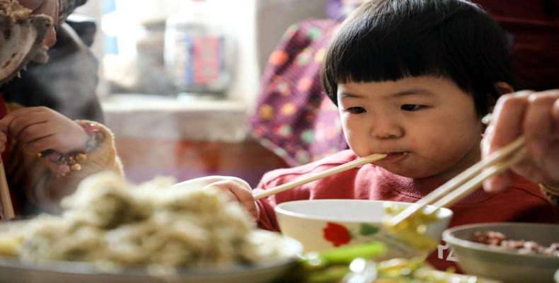 کودک چینی در حال غذا خوردن با چاپستیک؛ نشان‌دهنده فرهنگ غذایی و قدمت کشور چین
