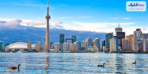 دیدنی‌های تورنتو   شهری پر از جاذبه‌های توریستی، فروشگاه‌ها متنوع، رستوران‌های خوشمزه با دکورها عجیب و زیبا، کافه‌های دنج، موزه‌هایی پر از شگفتی، خیابان‌هایی سرشار از حس زندگی؛ می‌خواهید بدانید این شهر کجاست؟  تورنتو، بزرگترین شهر کانادا، فراتر از تصور شماست. در اینجا هرگز دچار روزمرگی زندگی نخواهید شد؛ چون همیشه یک کار برای انجام دادن و یک تفریح و سرگرمی وجود دارد. از دیدنی‌های تورنتو بخواهیم بگوییم؛ تمام نشدنی است. در کوچه به کوچه این شهر مکان‌های جذابی وجود دارد که از کشف هر کدام به وجد می‌آیید. پس قبل از رزرو بلیط هواپیما تهران-تورنتو، درباره جاهای دیدنی این شهر بیشتر بدانید. 10 مورد از جاذبه‌های برتر تورنتو 2022 همانطور که گفتیم، جاذبه‌های تورنتو بسیار زیاد است. با این حال ما 10 مورد از دیدنی‌های تورنتو که برای گردشگران جذاب و فراموش نشدنی بودن را به شما معرفی می‌کنیم.  1)	برج  CN   برج CN یکی از هفت عجایب دنیای مدرن است؛ اینجا که از بزرگترین نقاط دیدنی کانادا به حساب می‌آید؛ هر گردشگری مجذوب خود می‌کند. البته بی دلیل هم نیست! می‌توانید با آسانسور به رستوران گردان 360 بروید و تجربه‌ای متفاوت و هیجان‌انگیز از غذا خوردن داشته باشید. حتی می‌توانید کمی جسارت به خرج دهید و روی کف شیشه‌ای در طبقه 113 راه بروید. اگر به این هیجان هم راضی نبودید 33 طبقه دیگر بالا بروید و از طریق اسکای پاد (Sky Pod) و دوربین‌های چشمی تمام شهر تورنتو را تماشا کنید. اما، اگر دل و جرات شما بیشتر از این چیزهاست، با بستن تسمه به بیرون از برج و لبه ساختمان بروید و با قدم زدن در ارتفاع 553 متری آدرنالین خونتان را به بالاترین سطح برسانید.   2)	موزه سلطنتی انتاریو (Royal Ontario Museum)   شاید شما علاقه‌ای به گشتن در موزه نداشته باشید؛ اما به ما اعتماد کنید؛ چون موزه سلطنتی انتاریو با آنچه که تابحال دیده‌اید، کاملا متفاوت است. بزرگترین موزه فرهنگ‌های جهان و تاریخ طبیعی که قدمتی 100 ساله دارد دقیقا در مرکز شهر تورنتو قرار گرفته است. با توجه به ورودی اصلی چشمگیر موزه، معروف به کریستال حتما این موزه به چشمتان می‌خورد و سریعا شما را جذب می‌کند. در داخل موزه، نمایشگاه‌هایی را در خود جای داده است که از دایناسورها تا مصر باستان تا اولین ملل کانادا را شامل می‌شود. خلاصه بگوییم در اینجا، با هنر، تاریخ، باستان شناسی، کانی شناسی، زمین شناسی، دیرینه شناسی، جانورشناسی، و عناصری از هر نوع شناسی دیگری که احتمالا می‌توانید تصور کنید، مواجه خواهید شد! 3)	آکواریوم ریپلی کانادا (Ripley’s Aquarium of Canada)   آیا تابحال با کوسه رو در رو شده‌اید؟ آکواریوم ریپلی به شما فرصت تجربه این هیجان را می‌دهد. البته فقط این نیست! در این آکواریوم حدود 16 هزار موجودات دریایی دیگر نیز وجود دارد؛ از خرچنگ‌های کوچک گرفته تا خرچنگ‌های غول پیکر 65 ساله، اختاپوس‌های بزرگ اقیانوس آرام و چتر دریایی گزنه. وجود یک تونل زیر آب در این آکواریوم با گذرگاه‌های متعدد باعث می‌شود تا دنیای زیر اقیانوس را از نزدیک تماشا کنید. این قطعا تجربه‌ای مهیج و فراموش‌نشدنی و جز جالب‌ترین دیدنی‌های تورنتو برای شما خواهد بود.  4)	منطقه تاریخی و تفریحی (Distillery Historic District)   وجود انواع رستوران‌ها، بوتیک‌ها، هنرهای دیدنی و سرگرمی‌های هیجان‌انگیز، باعث شهرت منطقه Distillery Historic District شده‌اند و آن را به یکی از جذاب‌ترین دیدنی‌های تورنتو تبدیل کرده است. برای یک گردشگر که به دنبال مکان‌های مدرن است اما در عین حال به دیدن جاهای قدیمی هم علاقه دارد؛ اینجا بهترین مکان است. غذاهایی خوشمزه در رستوران‌های با دکوراسیون جالب که در پشت دیوارهای آجری قرمز فرسوده پنهان شده‌اند. از طرفی هم وجود گالری‌های هنری و مکان‌های اجرای موسیقی زنده، حال و هوایی پر از زندگی و نشاط را برای گردشگران ایجاد می‌کنند.  5)	بازار کنزینگتون (Kensington Market)   در این بازار با دیدن مغازه‌های رنگارنگ و شور و هیجان خرید مردم، احساس سرزندگی و نشاط را از نزدیک لمس خواهید کرد. به غیر از این‌ها هر آنچه را که تصور می‌کنید، از کافه‌های عجیب و غریب با دکورهای جالب گرفته تا انواع و اقسام مغازه‌های مختلف را در این بازار در کنار هم خواهید دید. اصلا لازم نیست برای خرید و با هدف خاصی به این بازار بروید؛ قدم زدن و وقت گذرانی در این بازار کافی است. به ما اعتماد کنید، در اینجا حتما به شما خوش می‌گذرد.  6)	کازا لوما (Casa Loma)   باور کنید یا نه، تنها قلعه بزرگ در آمریکای شمالی در تورنتو واقع شده است. کاسا لوما به معنای واقعی کلمه همه چیزهایی را که از یک قلعه بخواهید دارد. برجک‌هایی که مناظر زیبایی از شهر را در جلوی چشمانتان قرار می‌دهند. یک کتابخانه بزرگ و نزدیک به 100 اتاق جالب که جستجو و کاوش در هر کدام بسیار هیجان‌انگیز و است. گذرگاه‌های مخفی که قدم زدن در آنها ممکن است کمی بترسید. همچنین، تونلی 245 متری به اصطبل، خانه کالسکه و پنج هکتار باغ پر از گل‌ها، مجسمه‌ها و فواره‌های زیبا دارد. کازا لوما قطعا از زیباترین دیدنی‌های تورنتو است که نباید آن را از دست داد.  7)	پارک ملی روژ (Rouge National Urban Park)   پارک ملی روژ، بهشت دیدنی‌های تورنتو و تنها پارک ملی تورنتو است. اگر دوست دارید به دل طبیعت منحصربفرد و زیبای تورنتو بروید؛ این پارک قطعا گزینه مناسبی خواهد بود. فضایی سرسبز با امکانات مناسب در مساحتی به اندازه 79 کیلومتر مربع این امکان را برای شما فراهم می‌کند تا انواع تفریحات متنوع مانند دوچرخه‌سواری، پیاده‌روی، شنا، کایاک سواری، کمپینگ با دوستانتان تجربه کنید و لحظات سرشار از نشاط و آرامش داشته باشید.  8)	جزایر تورنتو (Toronto Islands)   برای ورود به دنیایی کاملا متفاوت، فقط باید 10 دقیقه از شهر تورنتو سفر کنید. سوار کشتی شوید و سفری به جزایر تورنتو را آغاز کنید، مقصدی پر از جاذبه و از آرام‌ترین دیدنی‌های تورنتو که سرشار حس آرامش است. در اینجا، هیچ ماشینی وجود ندارد، بنابراین برای گشت و گذار در سه جزیره بزرگ آن که بوسیله یک سری مسیرها و پل‌ها به هم متصل شده‌اند؛ دوچرخه کرایه کنید. سواحل جزایر تورنتو بسیار زیبا، تمیز و دارای امکانات مناسب هستند که با وجود منظره‌های اطراف آن، این زیبایی دو چندان شده است. این را هم اضافه کنیم که قرار نیست فقط استراحت کنید و آفتاب بگیرید؛ قایق‌های پارویی، انواع ورزش‌های مهیج آبی و حتی اسب‌سواری در انتظار شما خواهند بود.  9)	بازار سنت لارنس (St. Lawrence Market)   درست در وسط منطقه تاریخی شهر قدیمی تورنتو، یکی از بهترین مقاصد غذاخوری شهر را خواهید یافت: بازار سنت لارنس. اگر به دنبال جایی از دیدنی های تورنتو هستید که خوشمزه باشد و بتوانید دلی از عزا درآورید، این بازار قطعا برای شماست. حتی اگر گرسنه هم نباشید با بوی محصولات تازه این بازار حتما هوس خوردن خواهید کرد. انواع غذاهای دریایی، پنیرهای خوشمزه، غذاهای آماده و.... . البته در این بازار پوشاک، جواهرات و وسایل دیگر برای سوغاتی هم پیدا می‌کنید.  10)	آبشار نیاگارا (Niagara Falls)   آبشار نیاگارا در شهر تورنتو نیست ولی فقط با حدود یک ساعت و نیم رانندگی می‌توانید به زیباترین و بزرگترین آبشار جهان برسید. فقط عظمت و زیبایی این آبشار را از نزدیک ببینید قطعا با خود می‌گویید که ارزش آمدن و وقت گذاشتن را دارد. آبشار نیاگارا از خارق‌العاده‌ترین دیدنی‌های تورنتو است. دیدن حجم بزرگ از آب خروشان که با شدت به سمت پایین سرازیر می‌شوند و رنگین کمان‌ها در کنار فضای سرسبز اطراف قطعا حال شما را خوب می‌کند. اگر حوصله نداشتی حتما سفر با تور را امتحان کنید ولی تحت هیچ شرایطی دیدن این آبشار را از دست ندهید.    در آخر فرقی نمی‌کند به تاریخ علاقه دارید یا به کشف مکان‌های جدید؛ اهل استراحت هستید یا به دنبال هیجان می‌گردیدغ تورنتو همه چیز برای شما دارد. جاذبه‌های این شهر سرسبز و زیبا تمام نشدنی است. اگر هوس سفر به مکان جالب و در عین حال مدرن را دارید قطعا تورنتو برای شما مناسب خواهد بود. به هر حال، چه برای سفر یا اقامت شناخت دیدنی‌های تورنتو دید وسیع‌تری از این شهر به شما می‌دهد. 